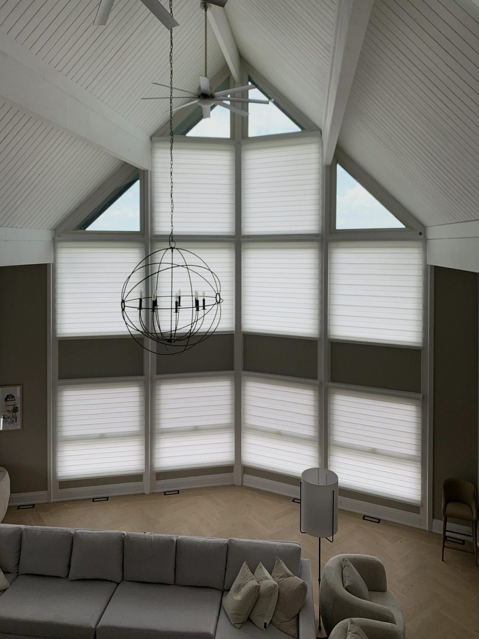 Cathedral vaulted great room with multi-panel window wall — triangular gable tops and rectangular panels all treated with coordinating cellular shades, Starlight Shutter GTA