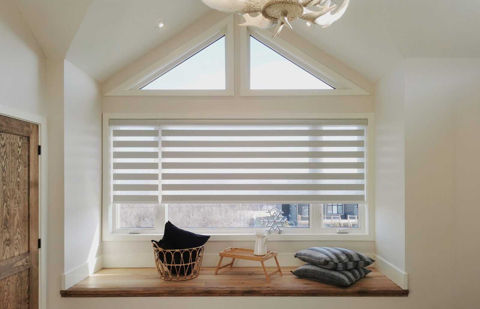 Custom grey zebra blinds over a window-seat nook with gable windows in a Toronto home