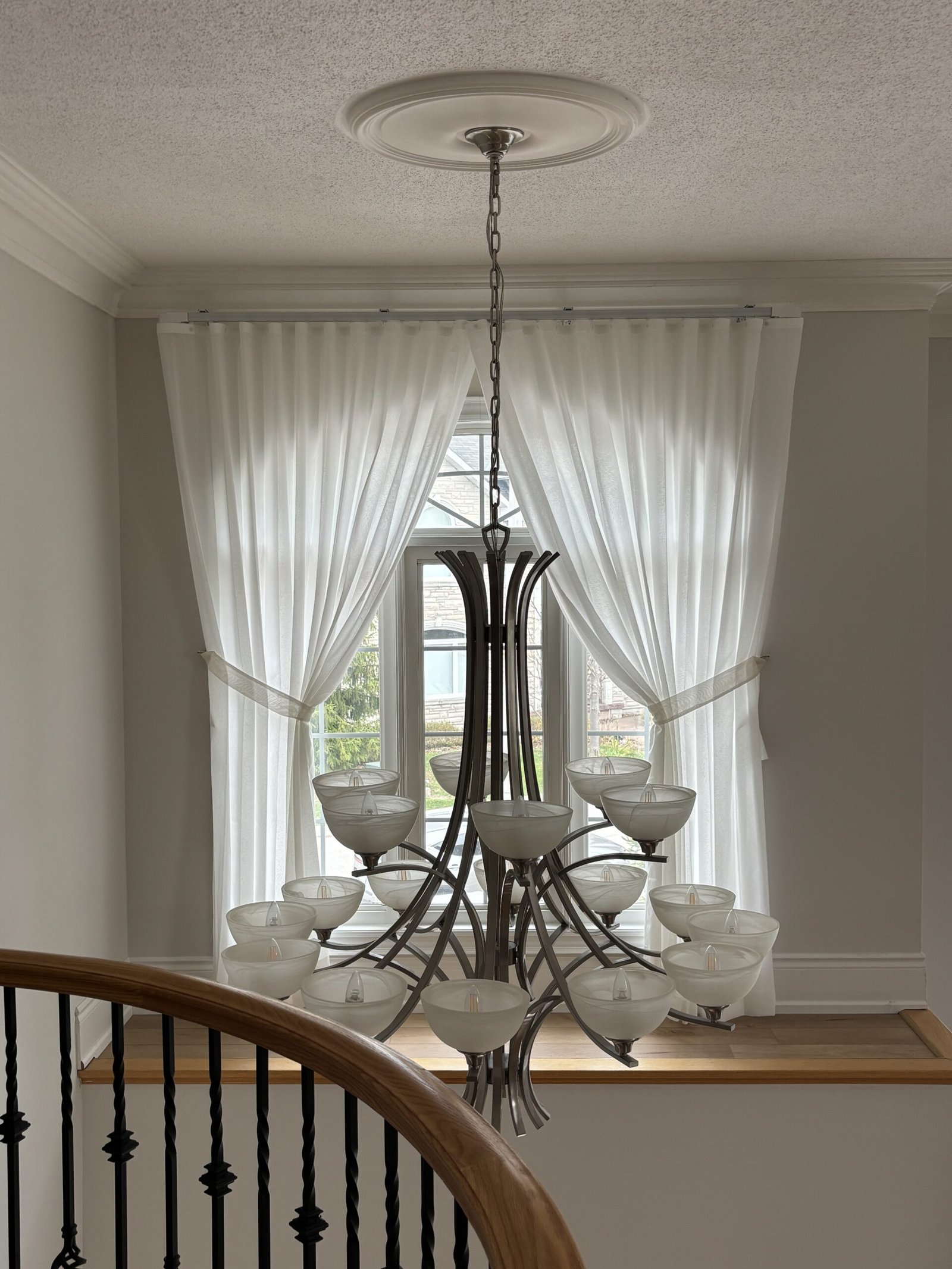 Transom window above a front door treated with a custom sheer shade — Starlight Shutter Toronto installation