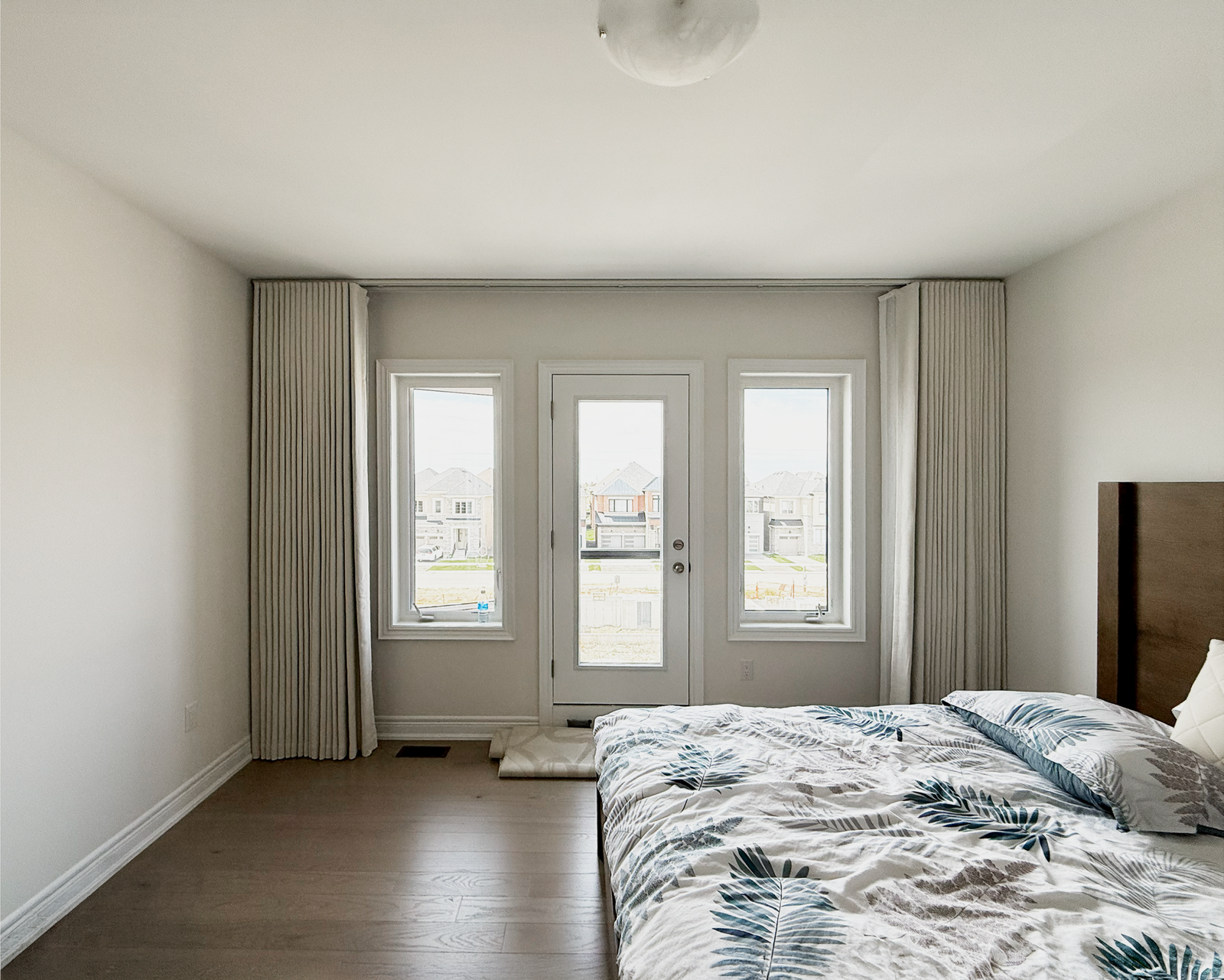 Custom drapery panels around a bedroom garden door in a Markham home