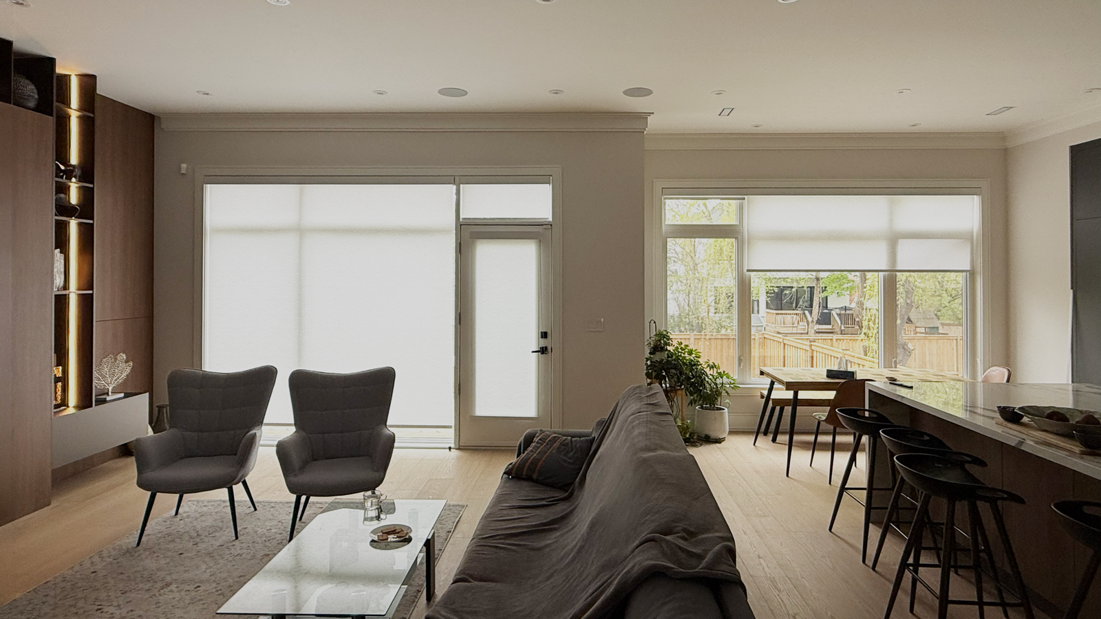 Roller blinds installed in an open-concept living room and dining room in a North York home by Starlight Shutter