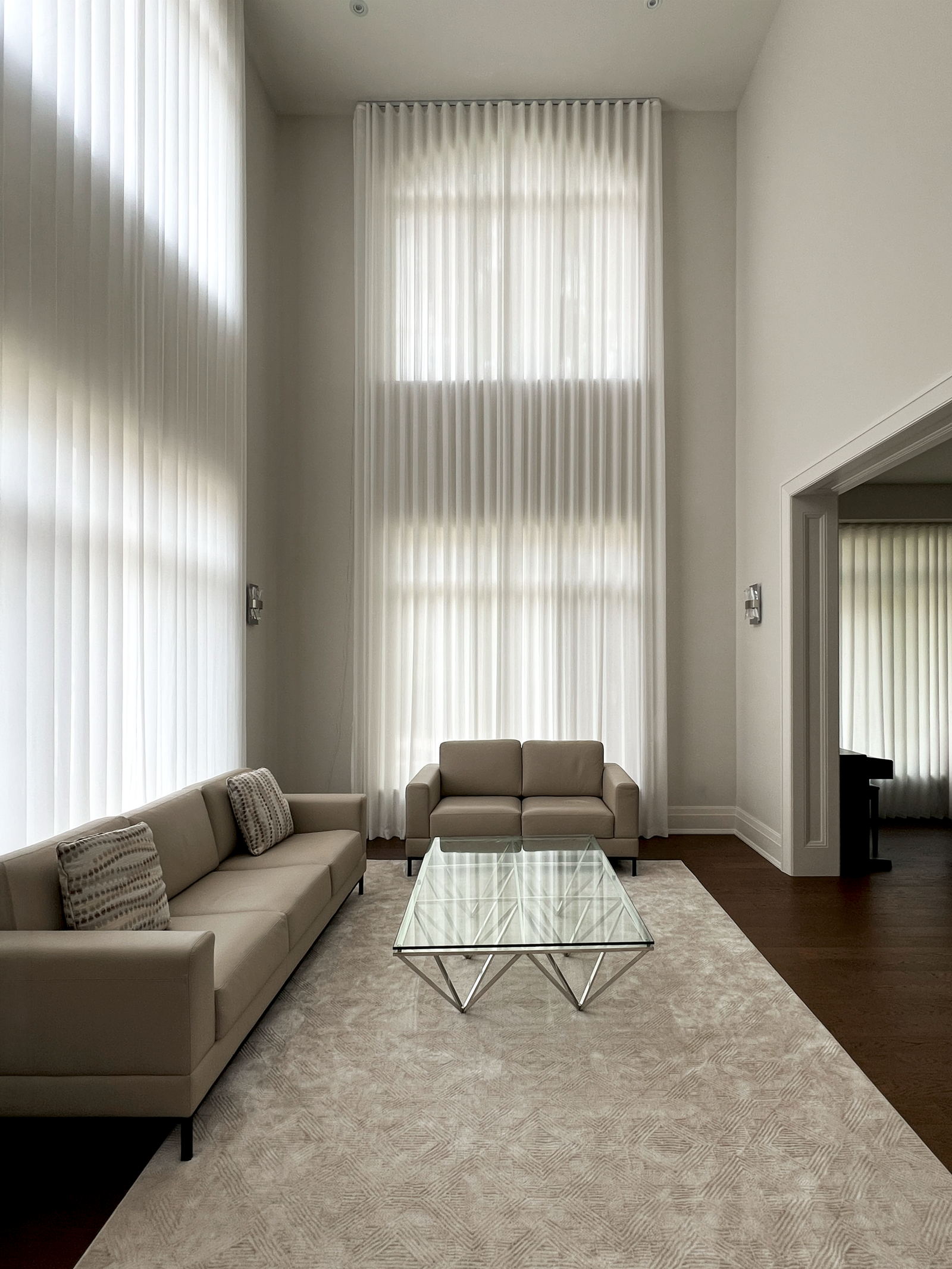 Custom window treatments on high living room windows in an Oakville home by Starlight Shutter