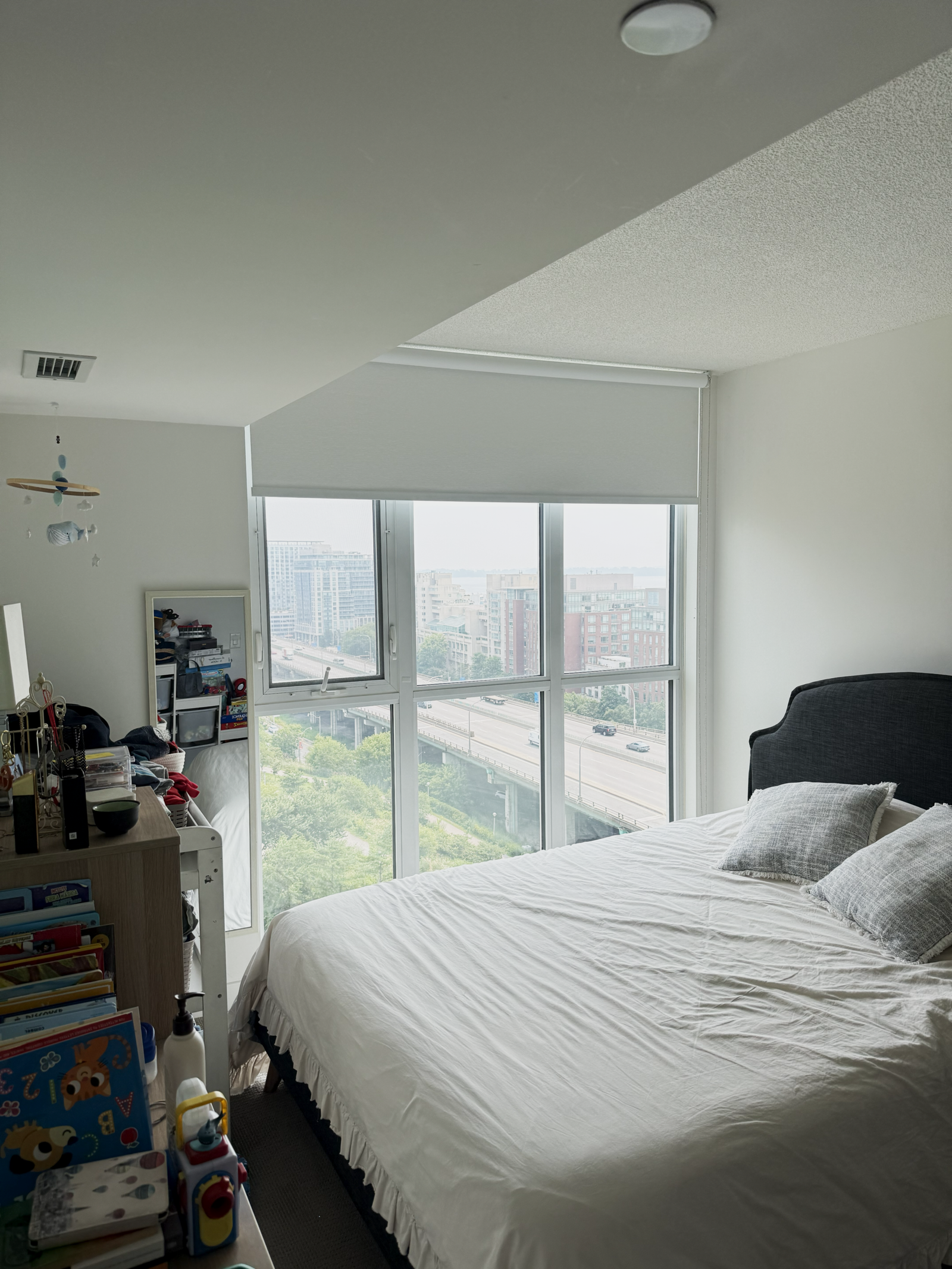 Blackout roller blinds in a condo bedroom for full darkness at night