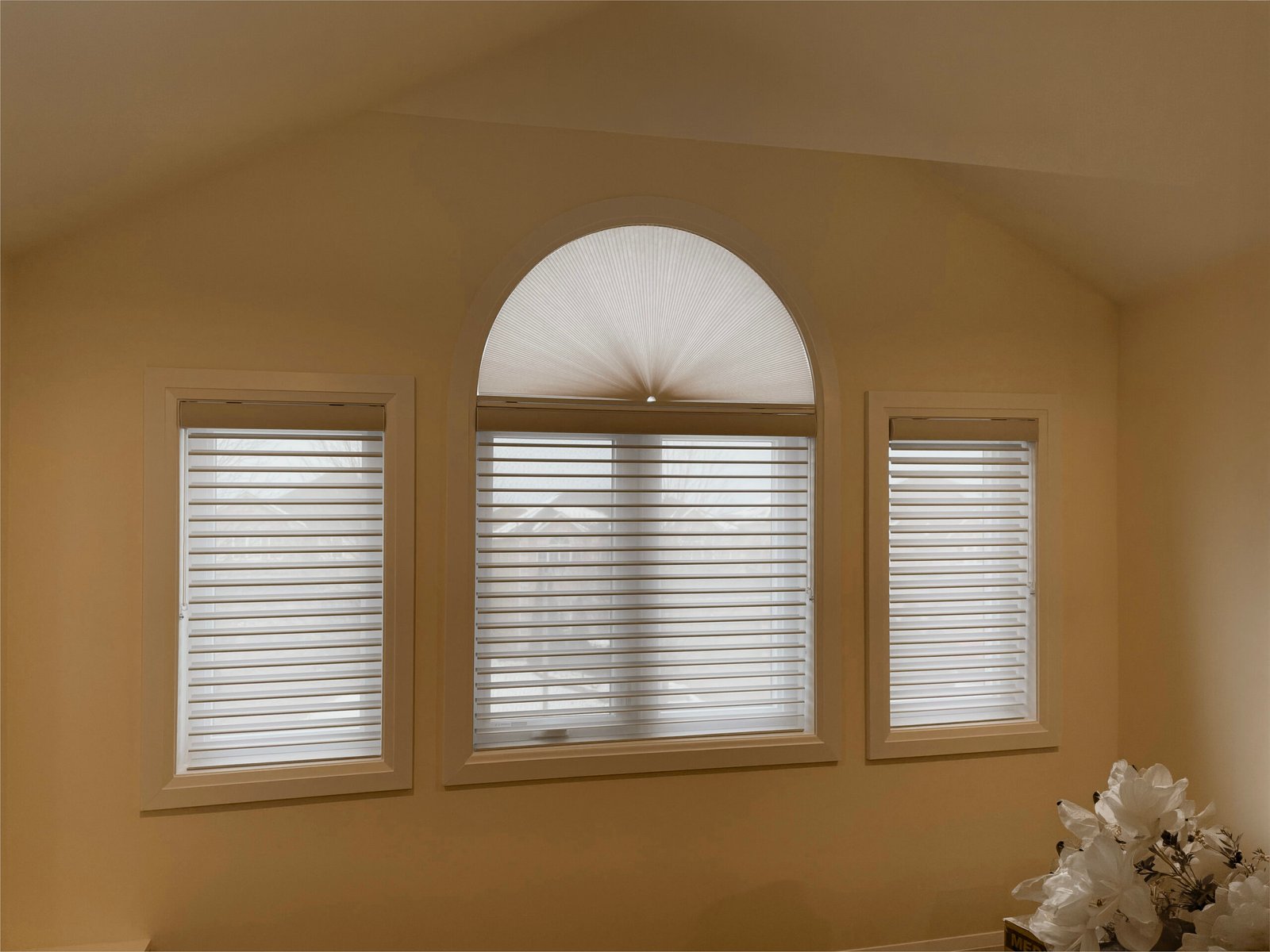 Fan-shaped honeycomb cellular shade fitted to an arched window in a Toronto home