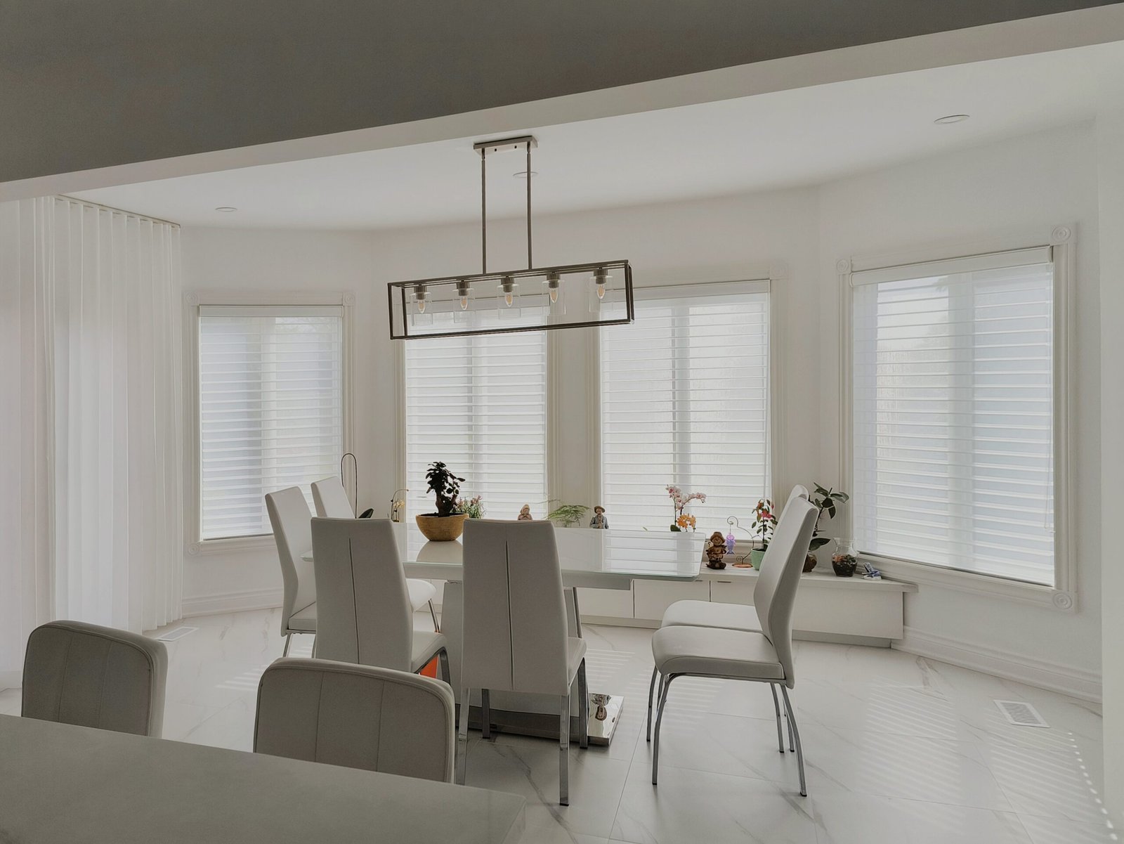 Custom white triple sheer Vienna shades on a bright bay window in a Toronto living room