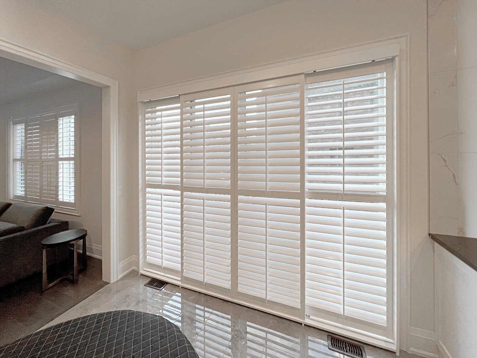 Custom sliding bypass track shutters across a patio door in a Toronto home