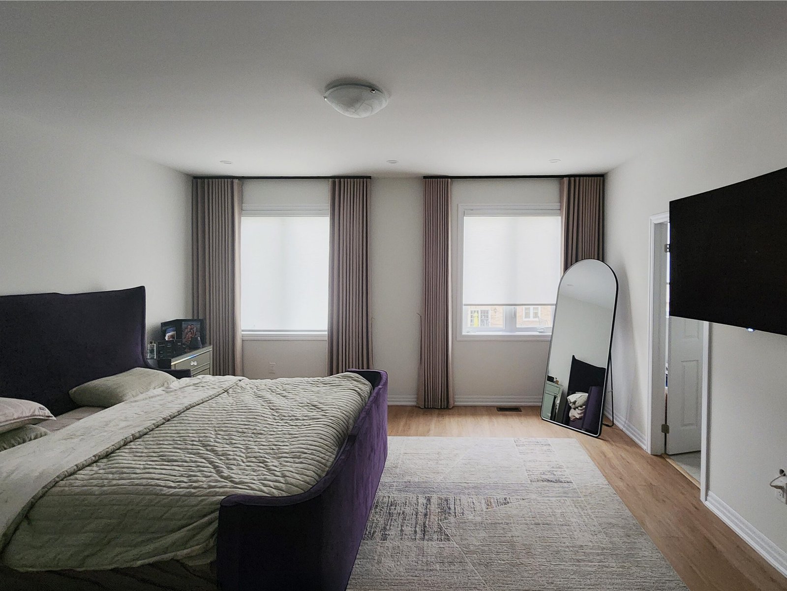 Blackout curtains layered with roller shades in a living room