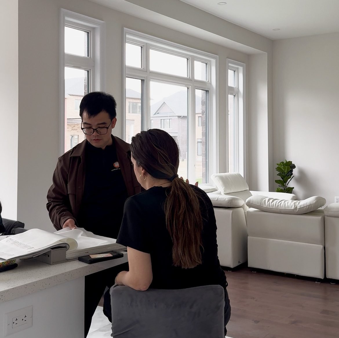 Starlight Shutter consultant showing window treatment fabric samples in a Toronto living room