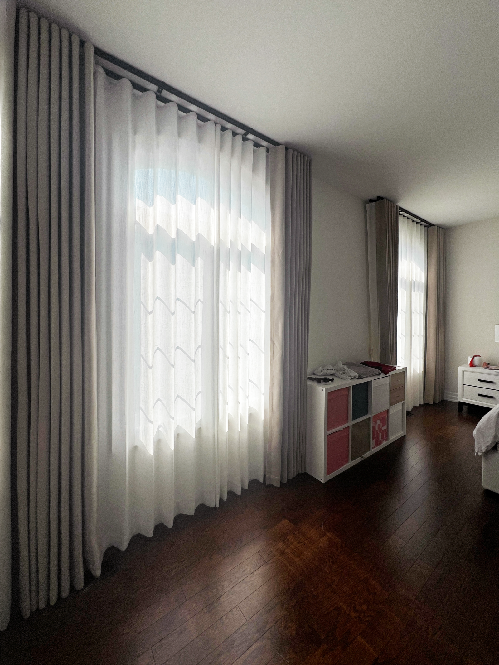 Sheer and blackout curtains layered on a bedroom window by Starlight Shutter