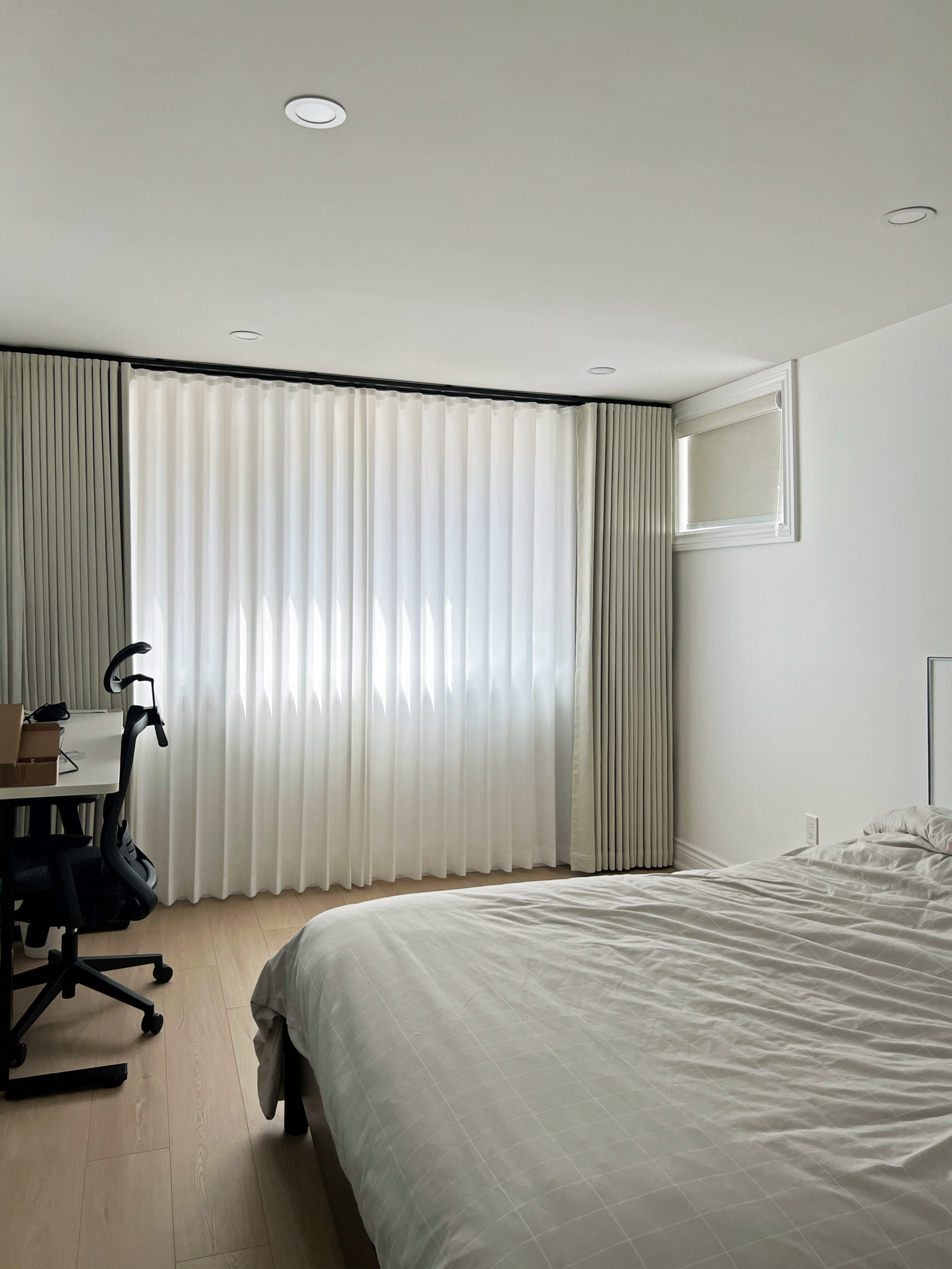 Roller blinds layered with sheer and blackout curtains in a Stouffville living room