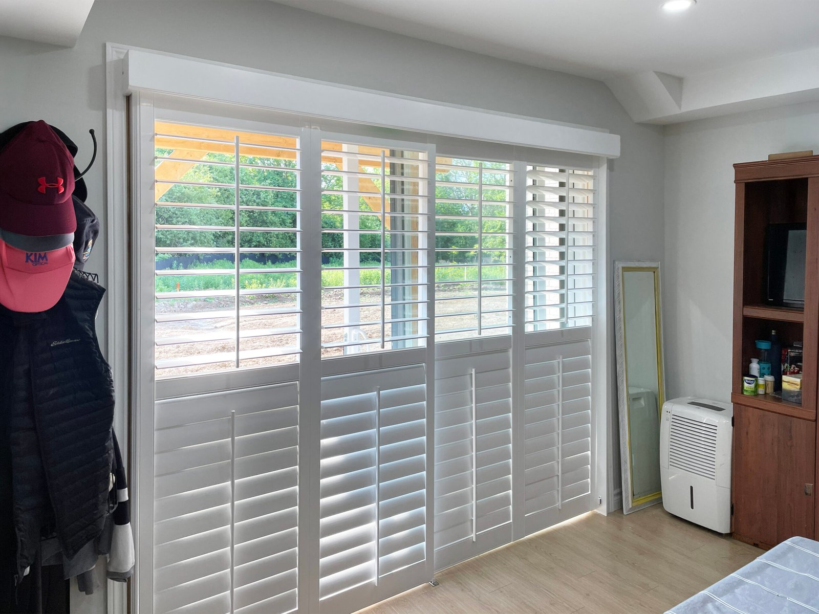 White bypass track shutters on a sliding door opening in a Toronto home, louvres tilted for filtered light