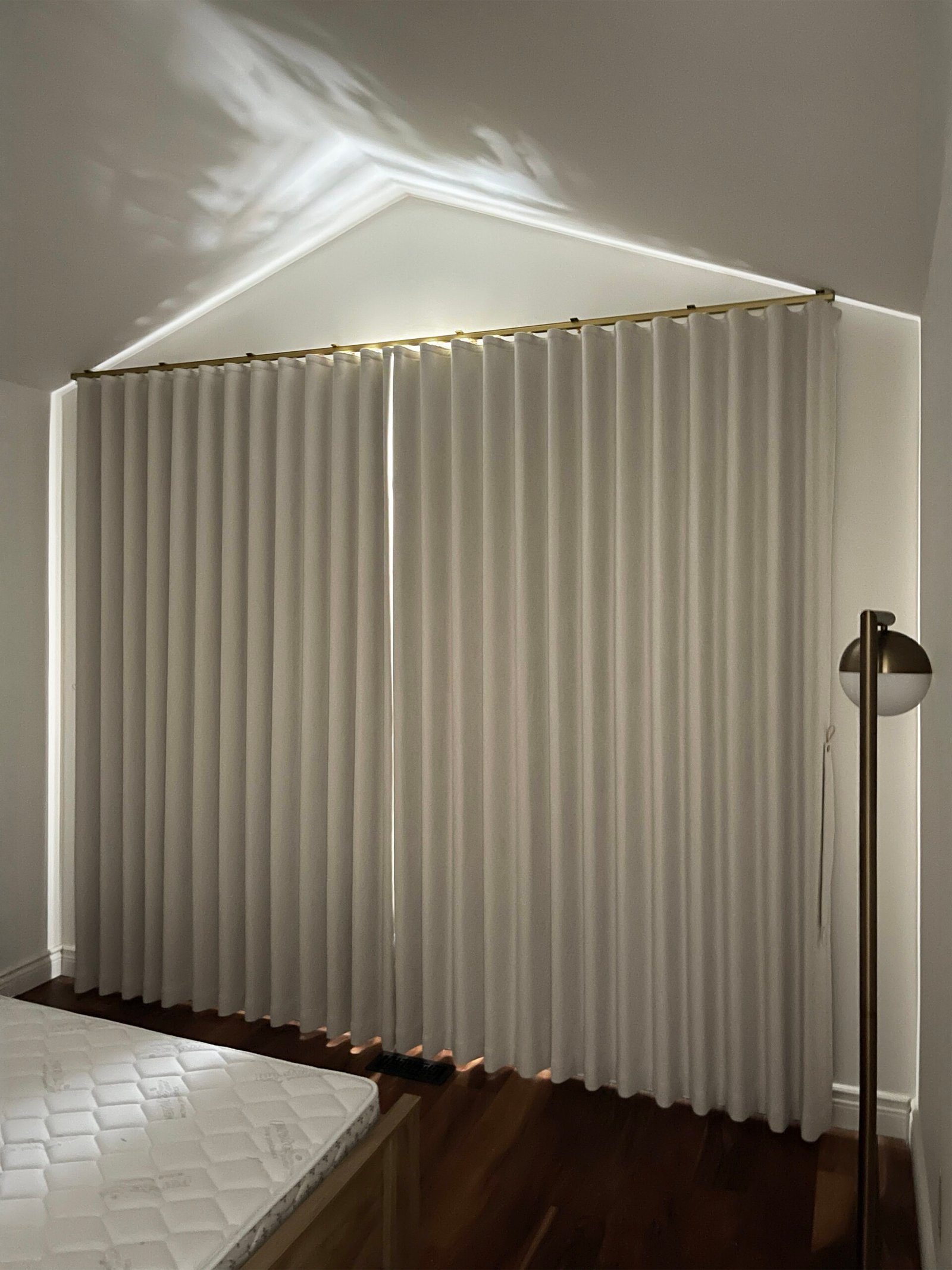 Blackout curtains fitted to a gable bedroom wall in an Aurora home by Starlight Shutter