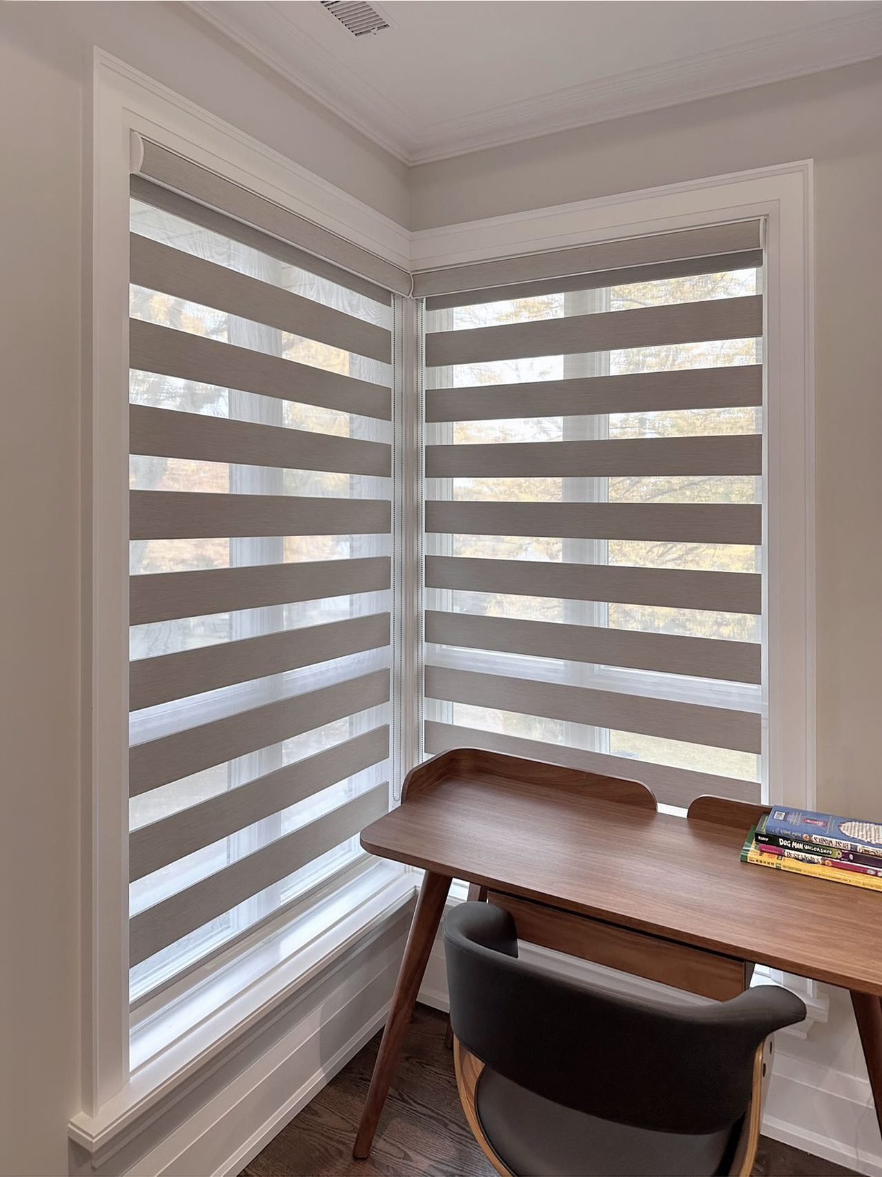 Zebra blinds on a corner window above a home-office desk in a Mississauga home