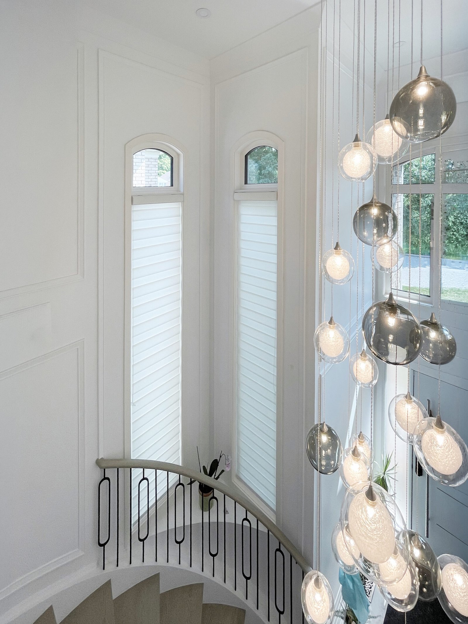 Zebra blinds on tall stairwell windows in a Burlington home