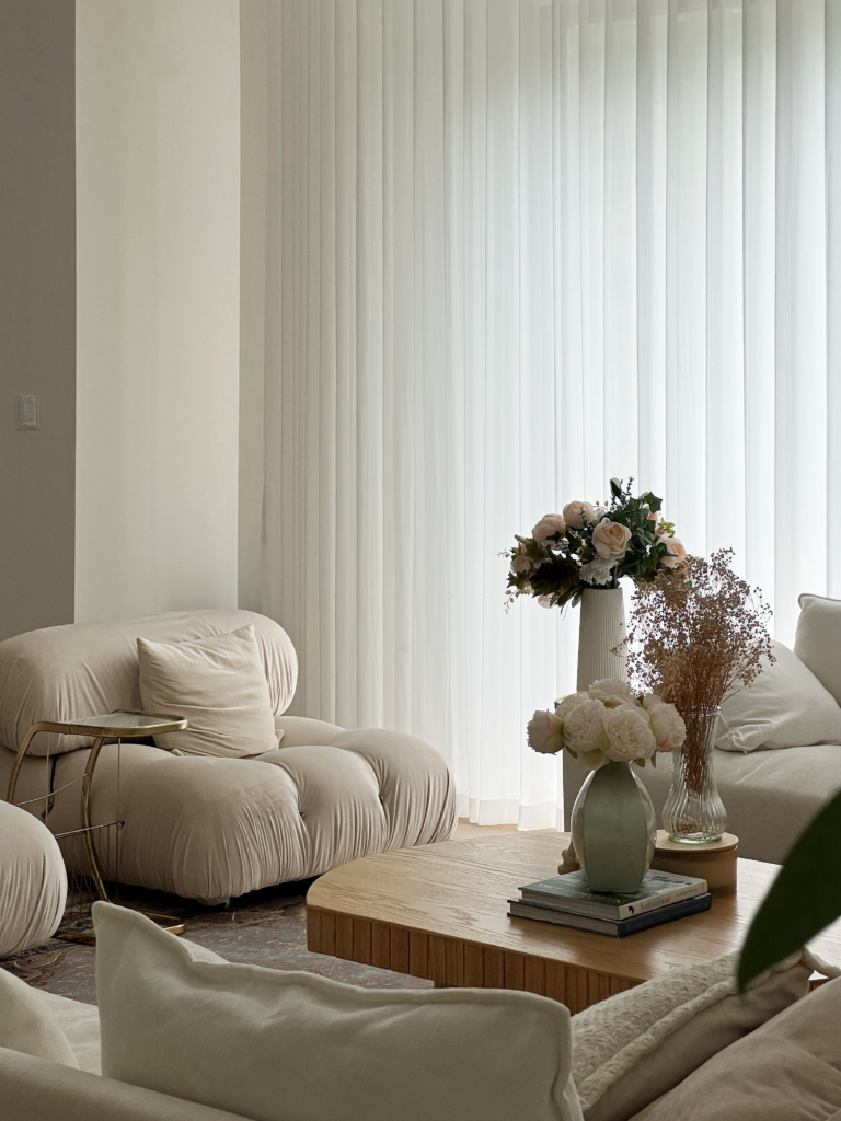Sheer ripplefold drapery behind boucle seating in a Mississauga living room.