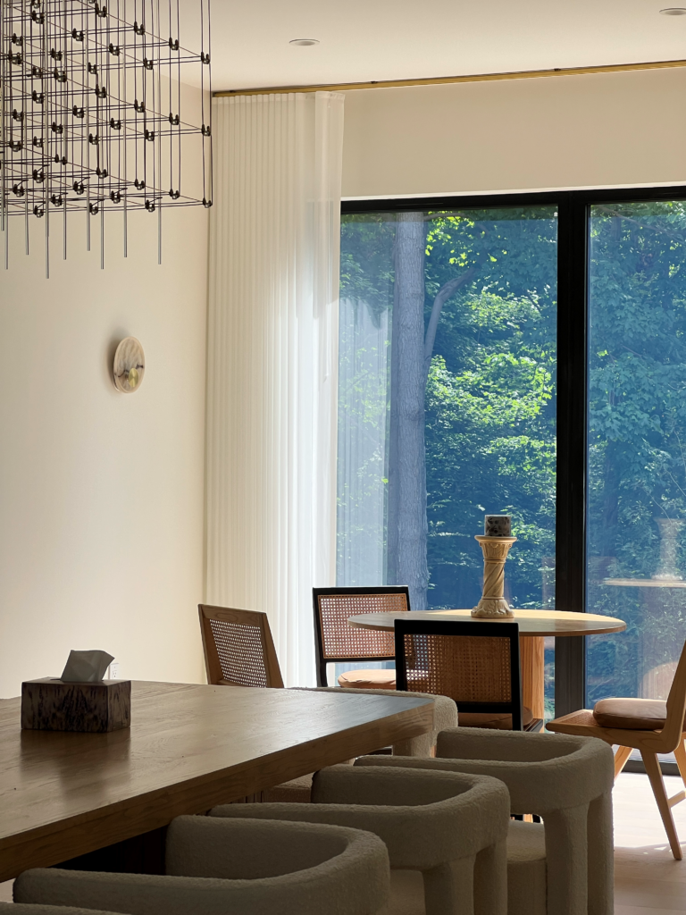 Ceiling mounted sheer drapery beside a black framed patio door in a Mississauga dining room.