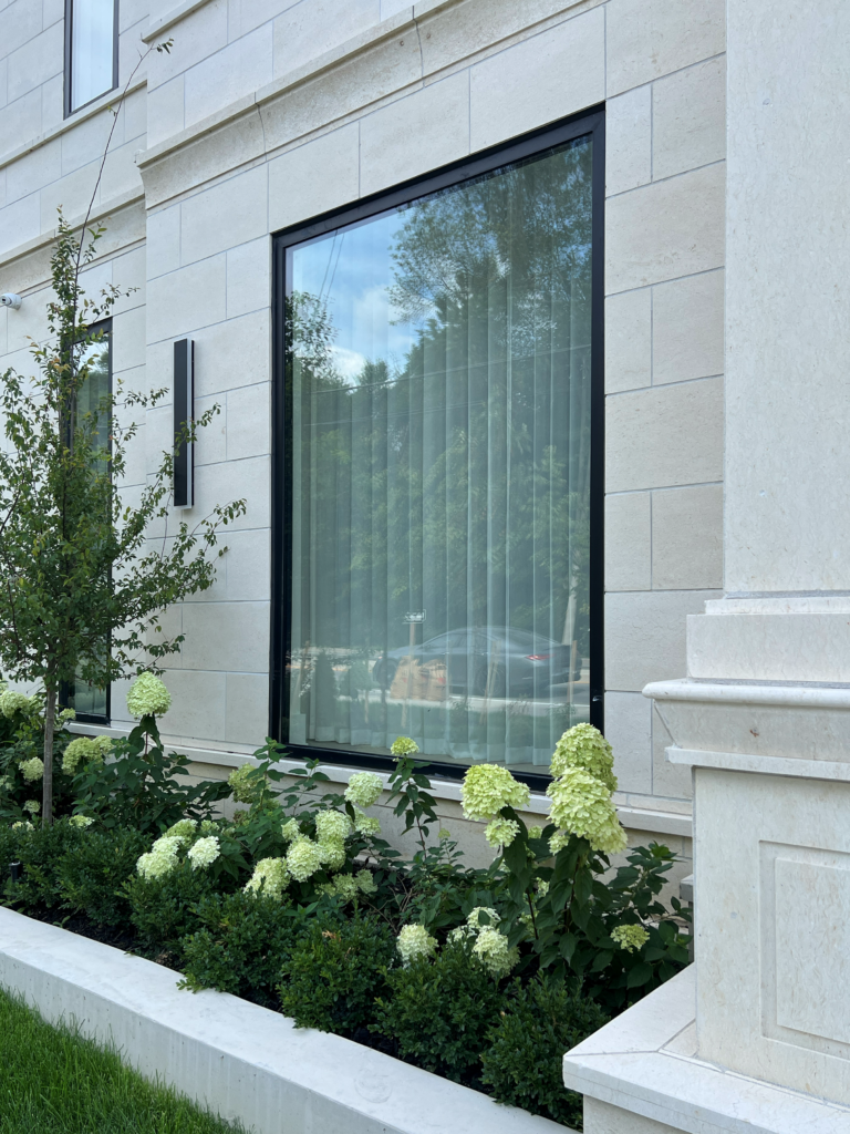Sheer drapery seen from outside a Mississauga home through a large picture window.